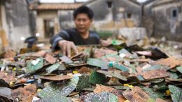 A worker sorts through stripped computer boards in Guiyu, China. Photo credit: Fortune.com