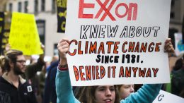 A protester holding a sign about the climate change denial of ExxonMobil at the protest Our Generation, Our Choice in Washington, D.C. (2015). Photo credit: Johnny Silvercloud